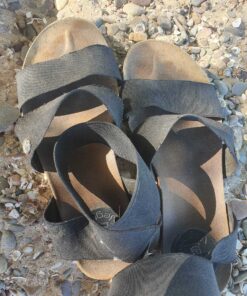 schwarze, vegane, lang getragene und verschwitzte Sandalen